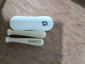 Detailed close-up of miniature wooden baseball bats with Giants engraving and GI logo charm