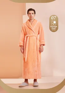 Dettaglio di un lussuoso accappatoio lungo in peluche rosa arancio con profili bianchi