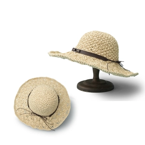 Straw sun hat for women with brown leather band and wide wavy brim for beach