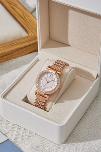 Dettaglio dell'orologio in oro rosa con strass, numeri romani e lancette blu in astuccio