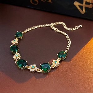 Elegant gold plated flower bracelet with emerald stones and zircon accents on leather