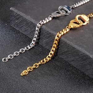 Men's stainless steel handcuff bracelets in gold and silver on a dark textured background