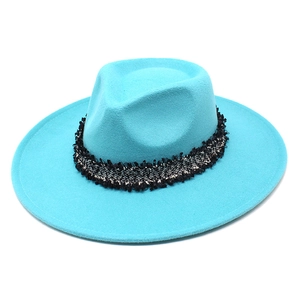 Détail d'un chapeau fedora en laine bleu ciel avec un ruban tissé noir et blanc chic