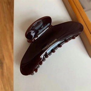 Close-up of a dark brown glossy hair claw clip with golden FRANCE Handmade lettering