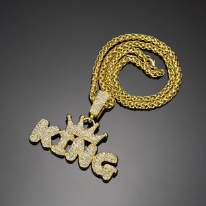 Macro shot of gold hip hop KING crown pendant with shimmering pave rhinestones