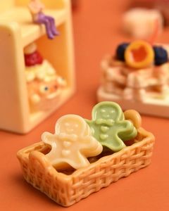 Miniature woven basket with beige and green gingerbread men for dollhouse decor