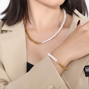 Detail of elegant pearl and gold Cuban chain necklace and bracelet set on a model