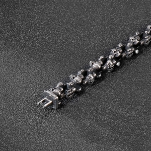 Retro gothic skull link bracelet in vintage silver finish on black textured background