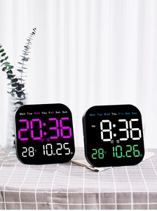 Macro shot of digital clock displaying time, date and temperature on a checkered tablecloth