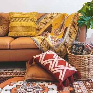 Bohemian outdoor camping blanket and geometric tufted pillows in warm earth tones
