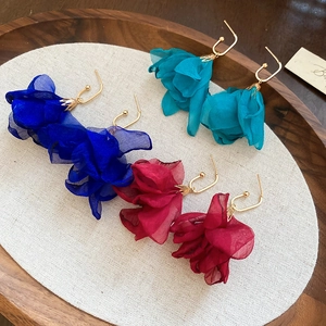 Detail of colorful chiffon flower drop earrings with golden hooks in blue, green and red