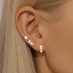 Detailed close-up of gold ear set featuring heart and water drop white zircon inlays
