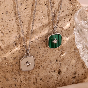 Macro shot of square starburst necklaces with shell inlays on natural stone