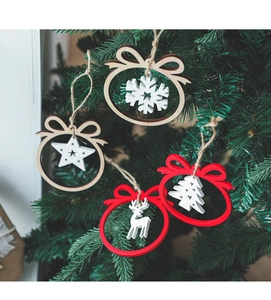 Close-up of wooden snowflake and deer ornaments hanging on a green Christmas tree