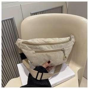 Detail of light beige corduroy chest bag with multi-zipper and adjustable strap