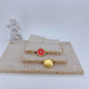 Summer gold-plated fruit lemon slice pendant with red enamel on a decorative stone base