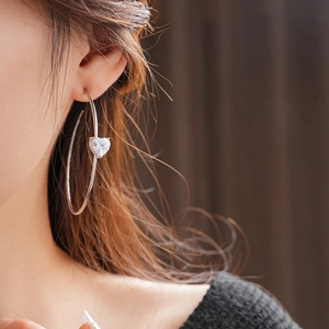 Détail des boucles d'oreilles C en argent avec pendentif en zircon en forme de cœur