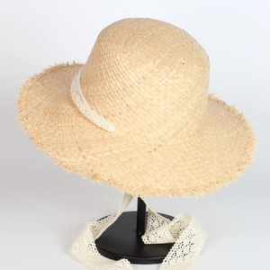 Straw sun hat with frayed brim and white lace ribbon for beach vacation style