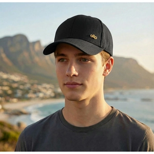 Close-up of black baseball cap with golden ollp metal logo detail in outdoor scenery