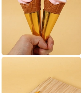 Detail of golden metallic foil wrappers for ice cream cones on a wooden display tray