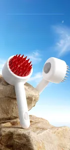 Close-up of ergonomic silicone pet bath brush with soft bristles on natural rock background