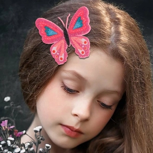 Close-up of pink butterfly hair clip with glitter details and blue floral patterns