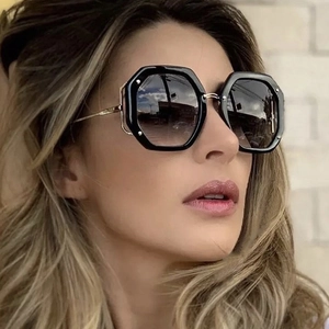 Chic women's oversized hexagonal sunglasses with black frames and gold metal temples