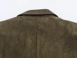 Detailed macro view of olive green faux suede fabric with center back seam stitching