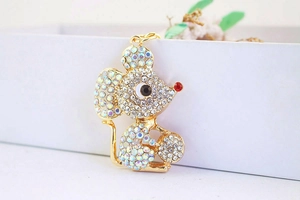 Close-up of golden zodiac mouse keychain with colorful rhinestones and red crystal nose