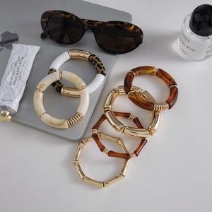 Macro detail of 6-piece resin and gold-plated acrylic bamboo bracelets set