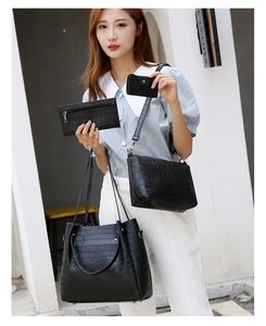 Detail of four-piece black crocodile pattern handbag set including tote and crossbody bag