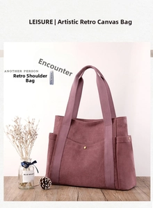 Close-up of burgundy canvas tote bag with side pockets and rivet details on wooden surface