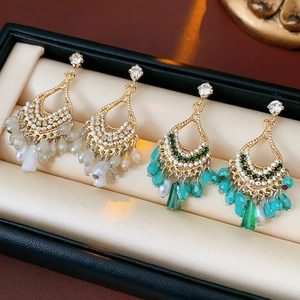 Close-up of bohemian water-drop earrings with rhinestones and beads in a black jewelry box