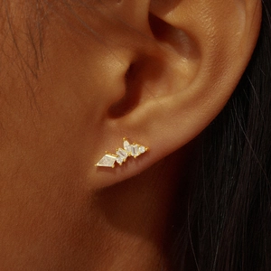 Close-up of a gold s925 silver cartilage stud with geometric zircon stones on an ear