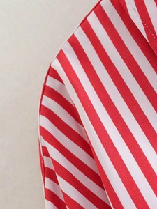 Macro shot of red and white striped poplin fabric showing fine stitching and texture