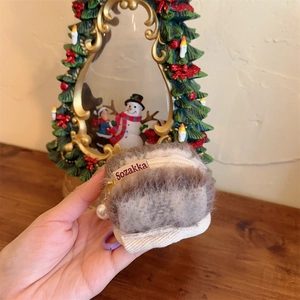Detailed view of plush fuzzy AirPods case with a gold zipper and elegant pearl pendant