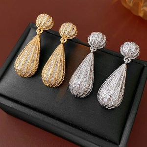 Detail van vintage druppeloorbellen in goud en zilver met ingelegde kleine edelstenen