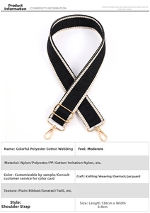 Detail of adjustable black and white jacquard bag strap with golden metal carabiners