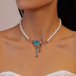 Close-up of blue starfish pendant necklace with pearls and crystal rhinestones on neck