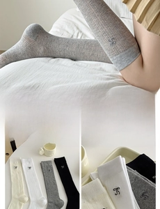 Detail of cotton calf socks with black bow embroidery and vertical knit texture