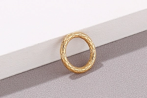 Detailansicht eines goldenen Titanstahlrings mit luxuriösem Rautenmuster im Steppdesign