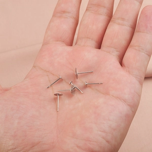 Flat pad stainless steel earring posts for jewelry making on palm background