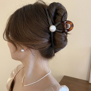 Detail of vintage amber tortoiseshell hair claw with a large pearl on elegant updo hair
