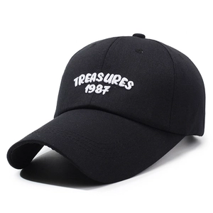 Black cotton baseball cap with white TREASURES 1987 embroidery shown at a 45-degree angle
