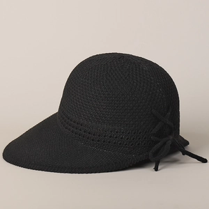Dettaglio cappello parasole in maglia nera con trama a rete e fiocco decorativo laterale