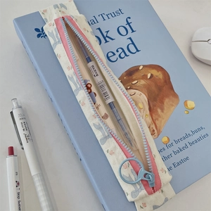 Floral pencil case with elastic strap on a book cover showing detailed canvas texture
