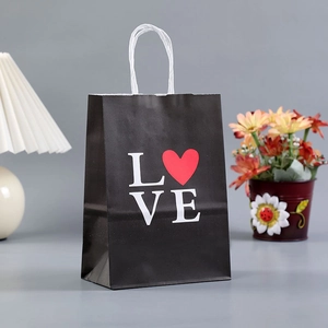 Detail of black paper gift bag with white LOVE text and a red heart icon