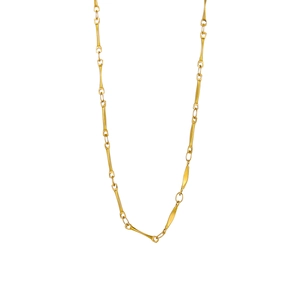 Detailed view of the gold bone-shaped link chain and metallic texture of the necklace