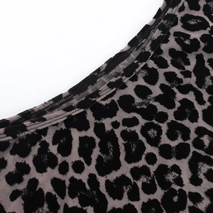 Detail shot of sheer leopard print mesh fabric with flocked velvet texture and piping