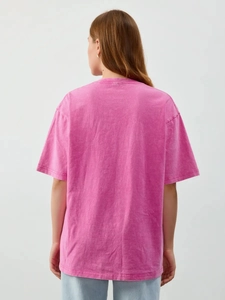 Rear view of vintage washed pink cotton t-shirt showing loose fit and fabric texture
